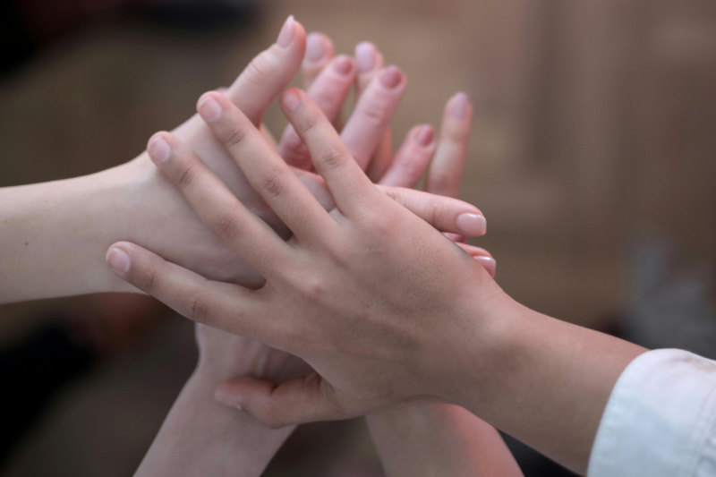 übereinander liegende Kinderhände  
